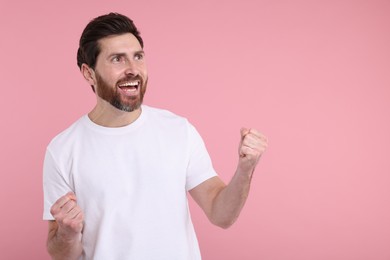 Photo of Portrait of happy surprised man on pink background, space for text