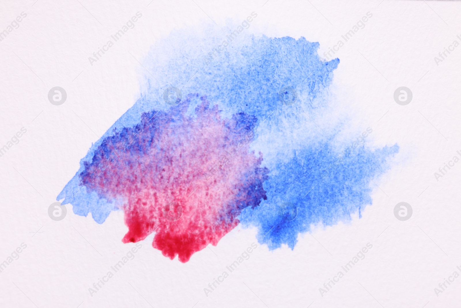 Photo of Blot of bright watercolor paints on white paper, top view