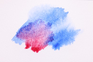 Photo of Blot of bright watercolor paints on white paper, top view