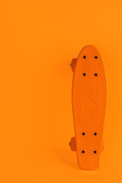 Image of Bright skateboard on orange background. Space for text