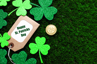 Photo of Flat lay composition with clover leaves on green grass, space for text. St. Patrick's Day celebration