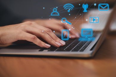 Image of Woman working with laptop at wooden table, closeup. Modern technology concept