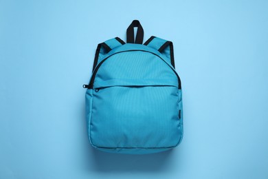 Photo of Stylish backpack on light blue background, top view