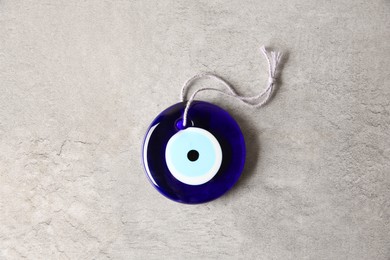 Evil eye amulet on light grey table, top view