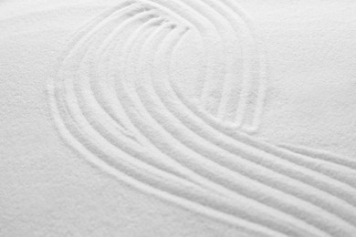 Photo of White sand with pattern as background, closeup. Concept of zen and harmony