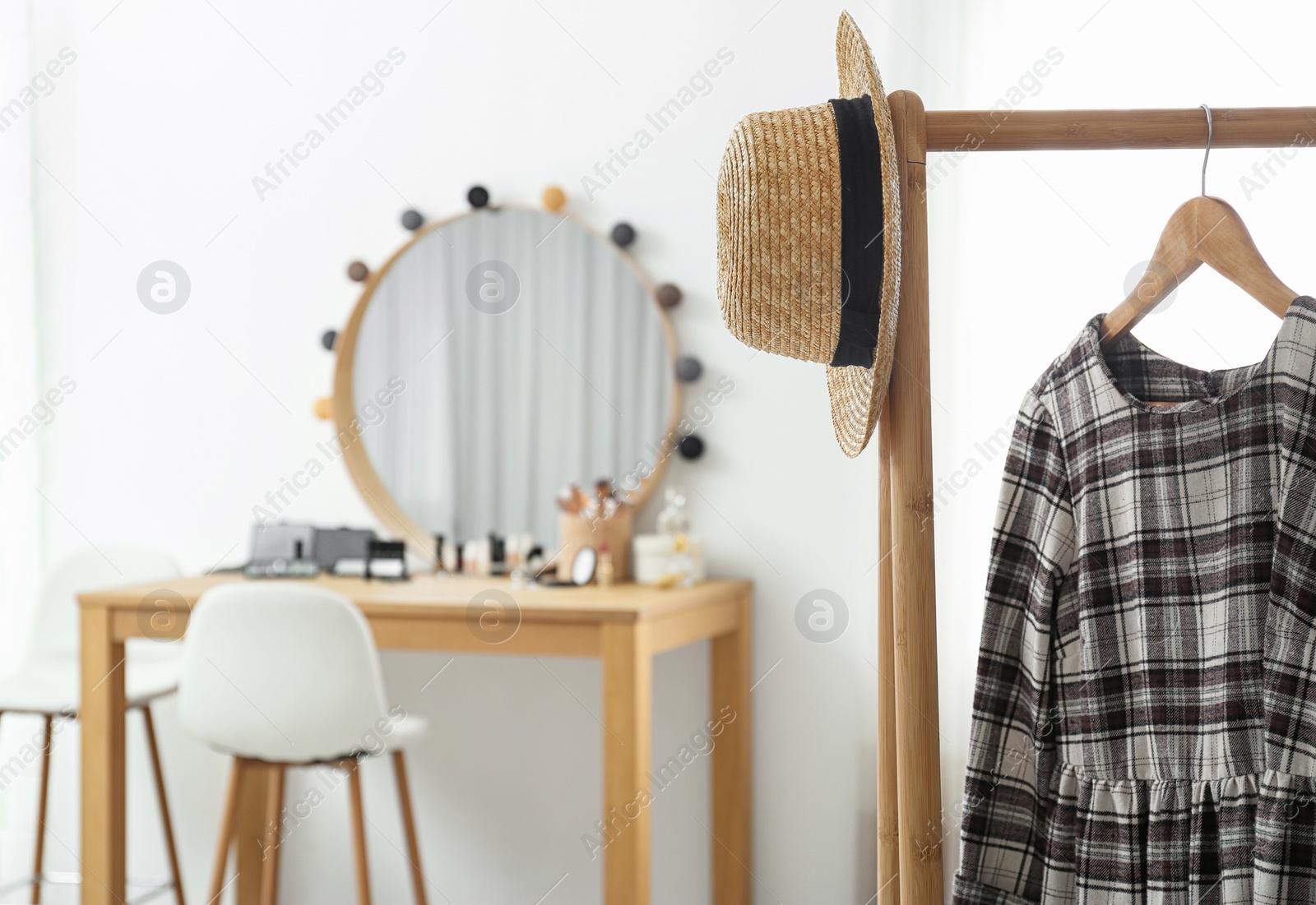 Photo of Hanger with stylish cloth and hat on rack in makeup room. Space for text