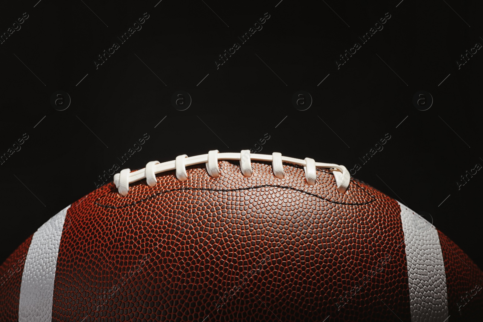 Photo of New American football ball on dark background