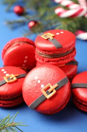 Beautifully decorated Christmas macarons on blue background, closeup