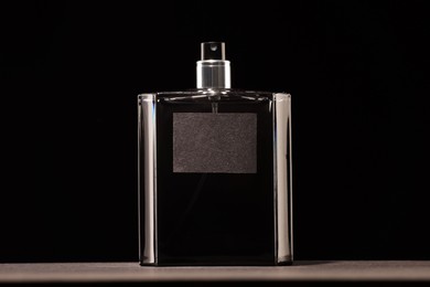 Luxury men`s perfume in bottle on grey table against black background