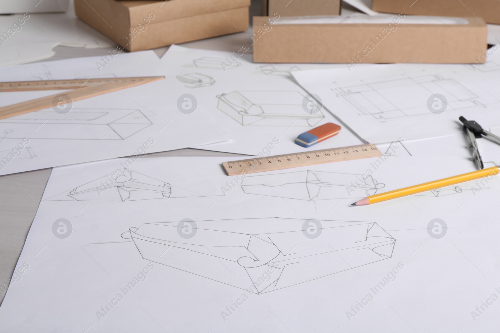 Photo of Creating packaging design. Drawings, boxes and stationery on light table, closeup