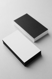 Photo of Blank black and white business cards on light background. Mockup for design