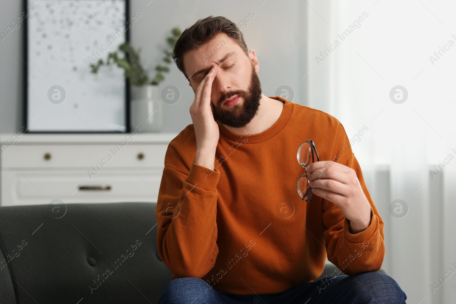 Photo of Overwhelmed man with glasses suffering at home