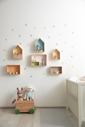 Stylish baby room interior design with house shaped shelves and crib