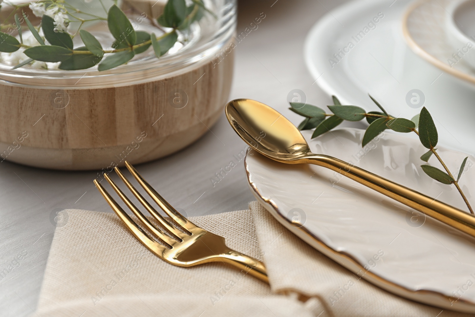 Photo of Elegant cutlery with green leaves on table, closeup. Festive setting