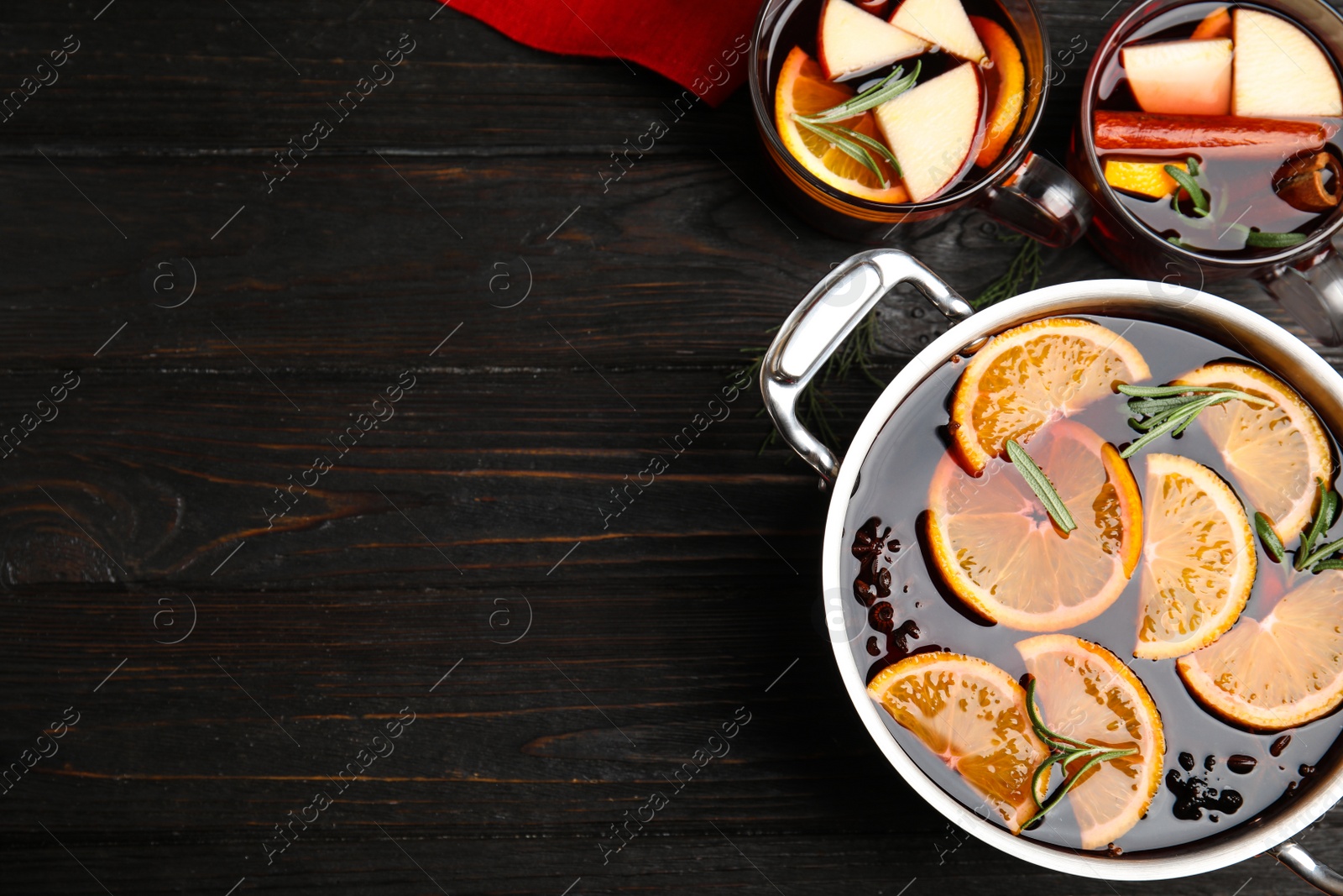 Photo of Tasty mulled wine with spices on wooden table, flat lay. Space for text