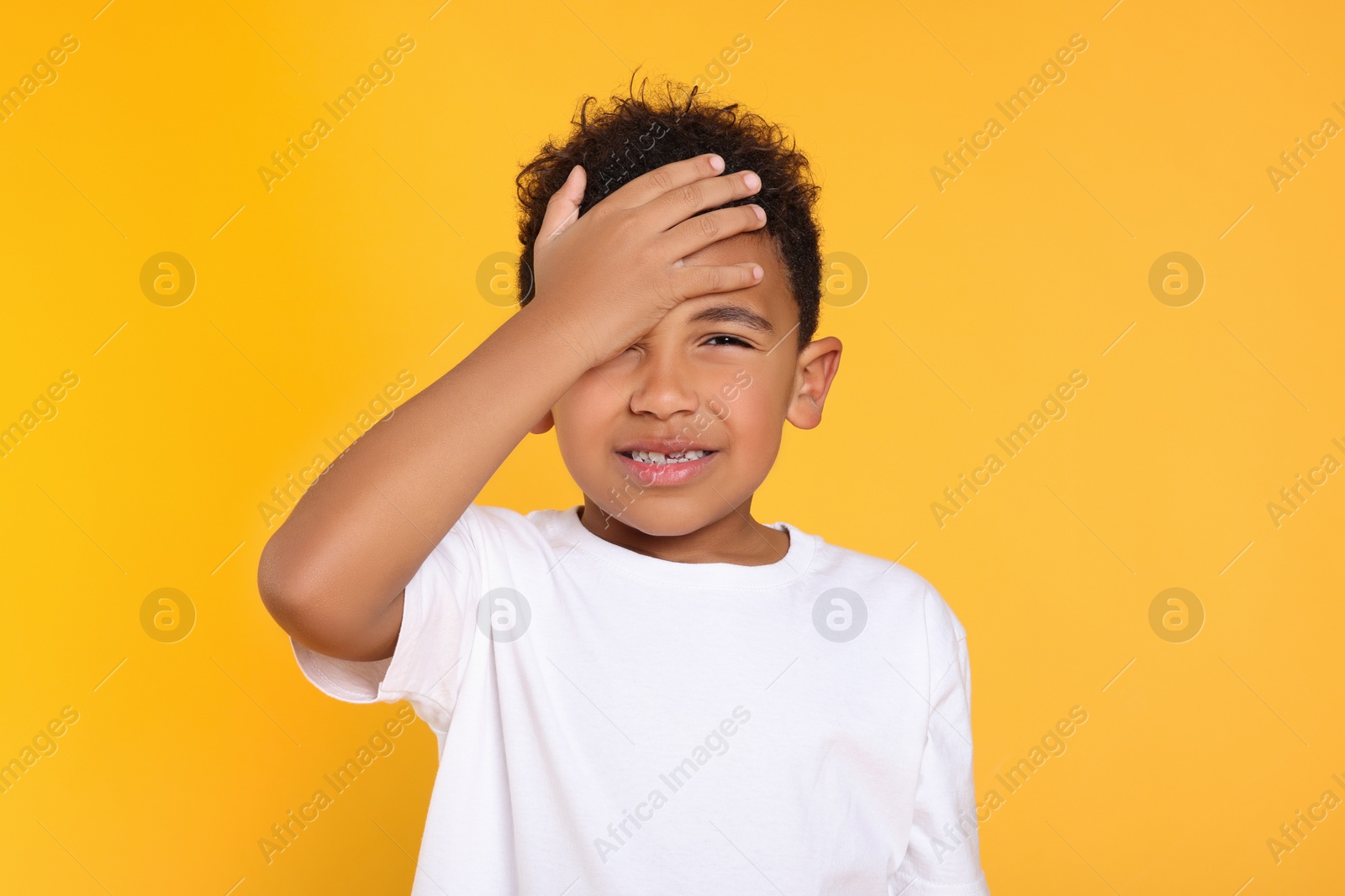 Photo of Portrait of emotional African-American boy on yellow background