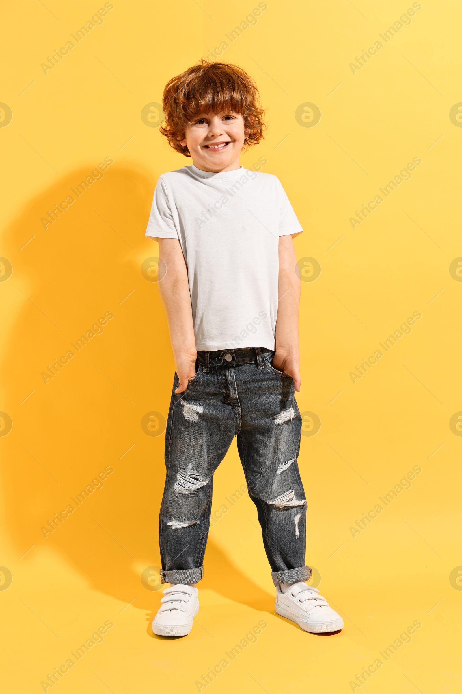 Photo of Fashion concept. Stylish boy posing on yellow background