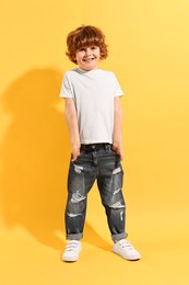 Fashion concept. Stylish boy posing on yellow background