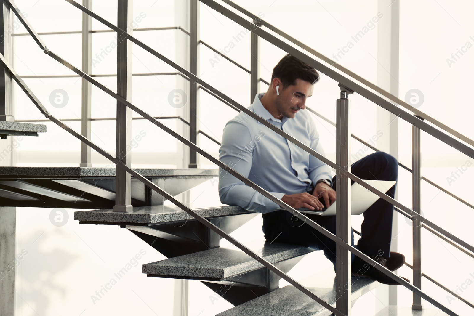 Photo of Portrait of young man with laptop indoors