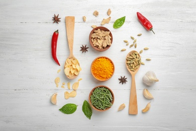 Flat lay composition with different aromatic spices on wooden background