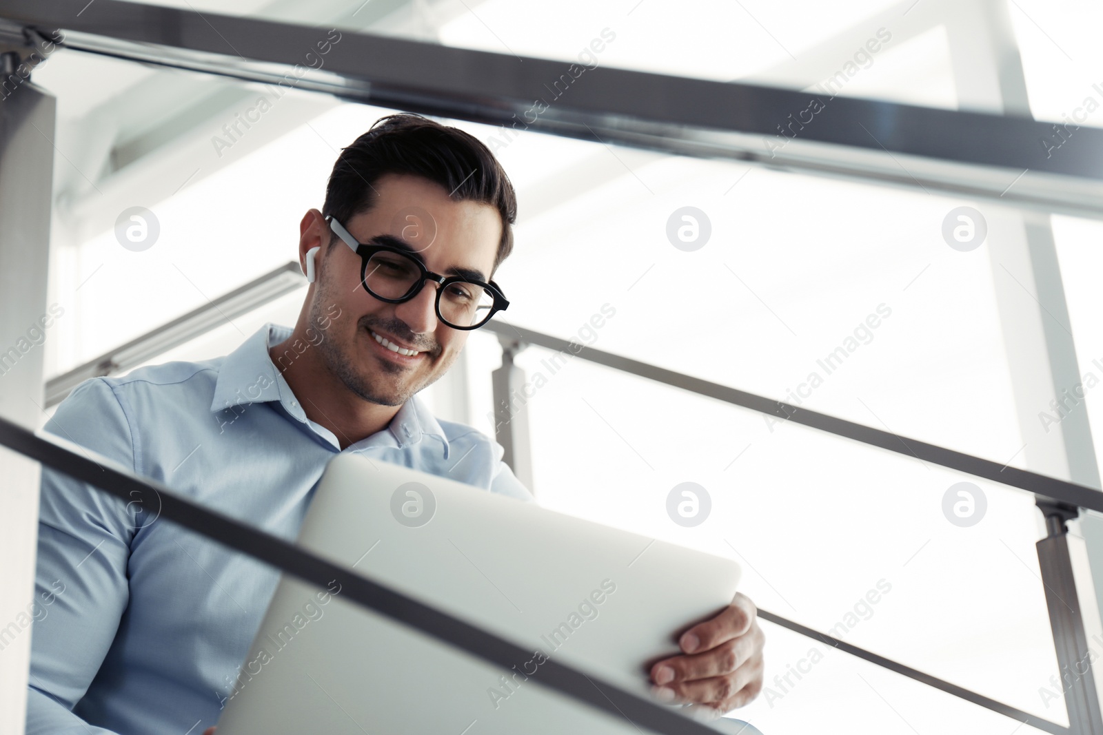 Photo of Portrait of young man with laptop indoors