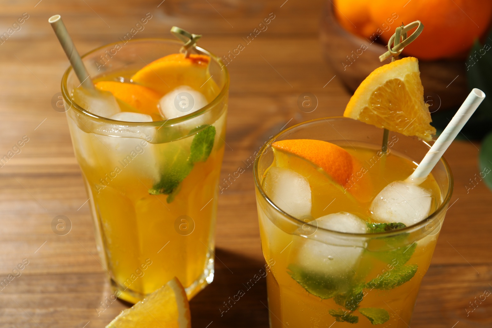 Photo of Delicious orange soda water on wooden table, closeup