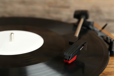 Photo of Vinyl record on turntable against blurred background, closeup