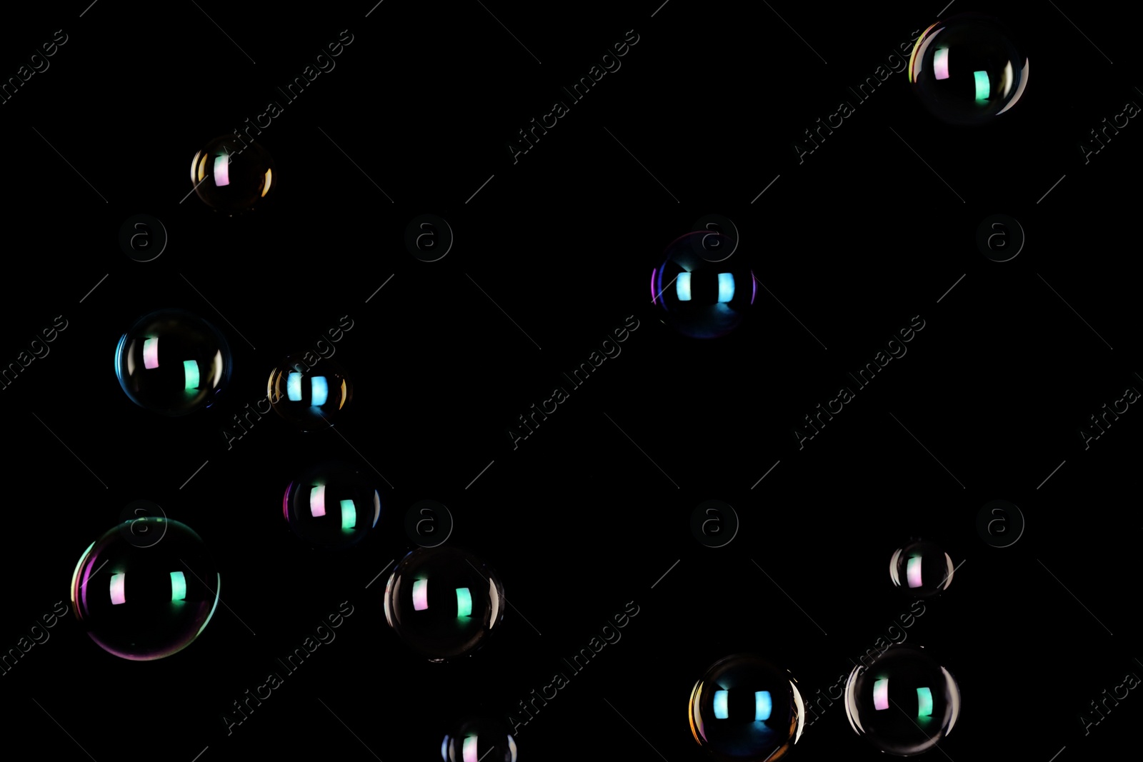 Photo of Beautiful translucent soap bubbles on dark background