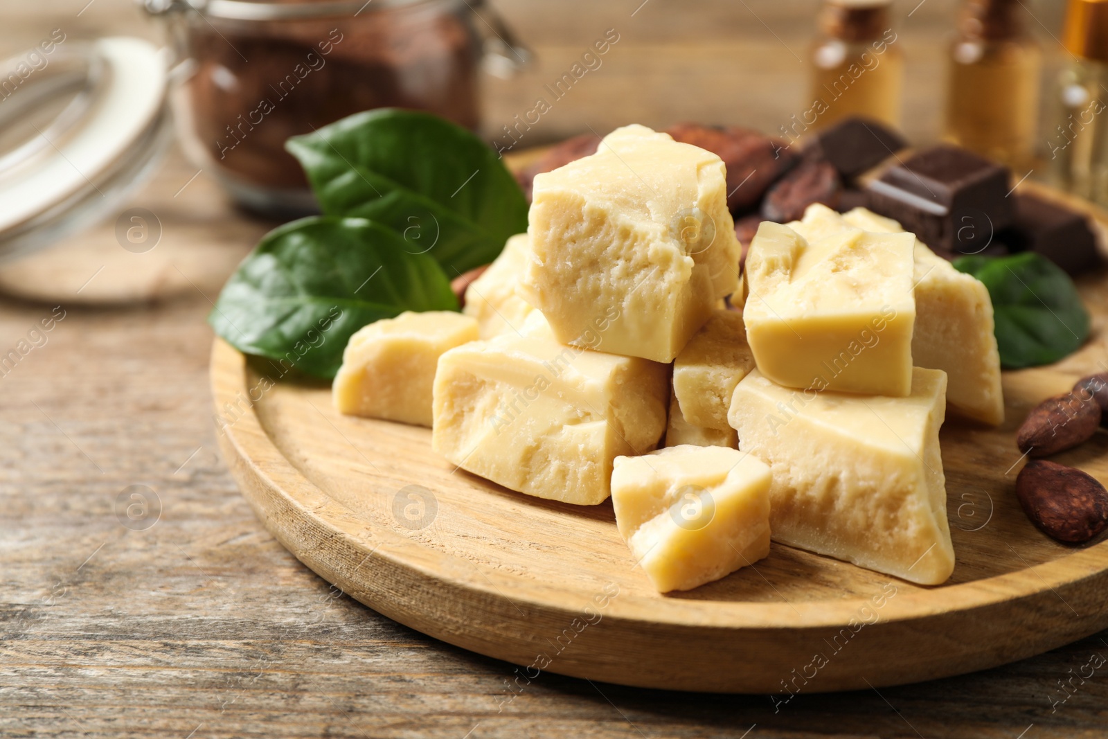 Photo of Organic cocoa butter on wooden table, closeup