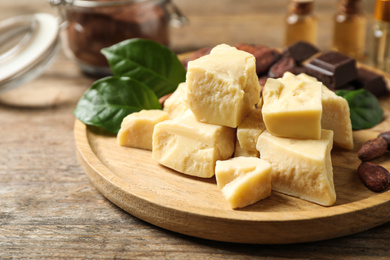 Organic cocoa butter on wooden table, closeup