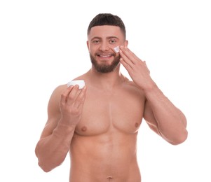 Photo of Handsome man applying cream onto his face on white background