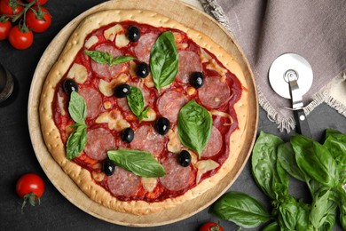 Photo of Delicious homemade pita pizza and ingredients on black table, flat lay