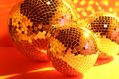 Photo of Many shiny disco balls indoors, toned in orange