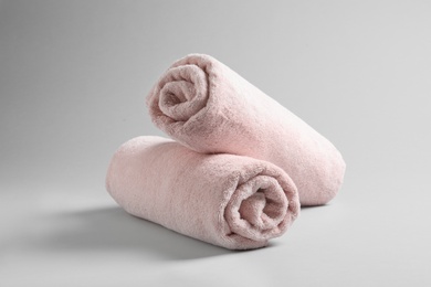 Photo of Fresh soft rolled towels on light background