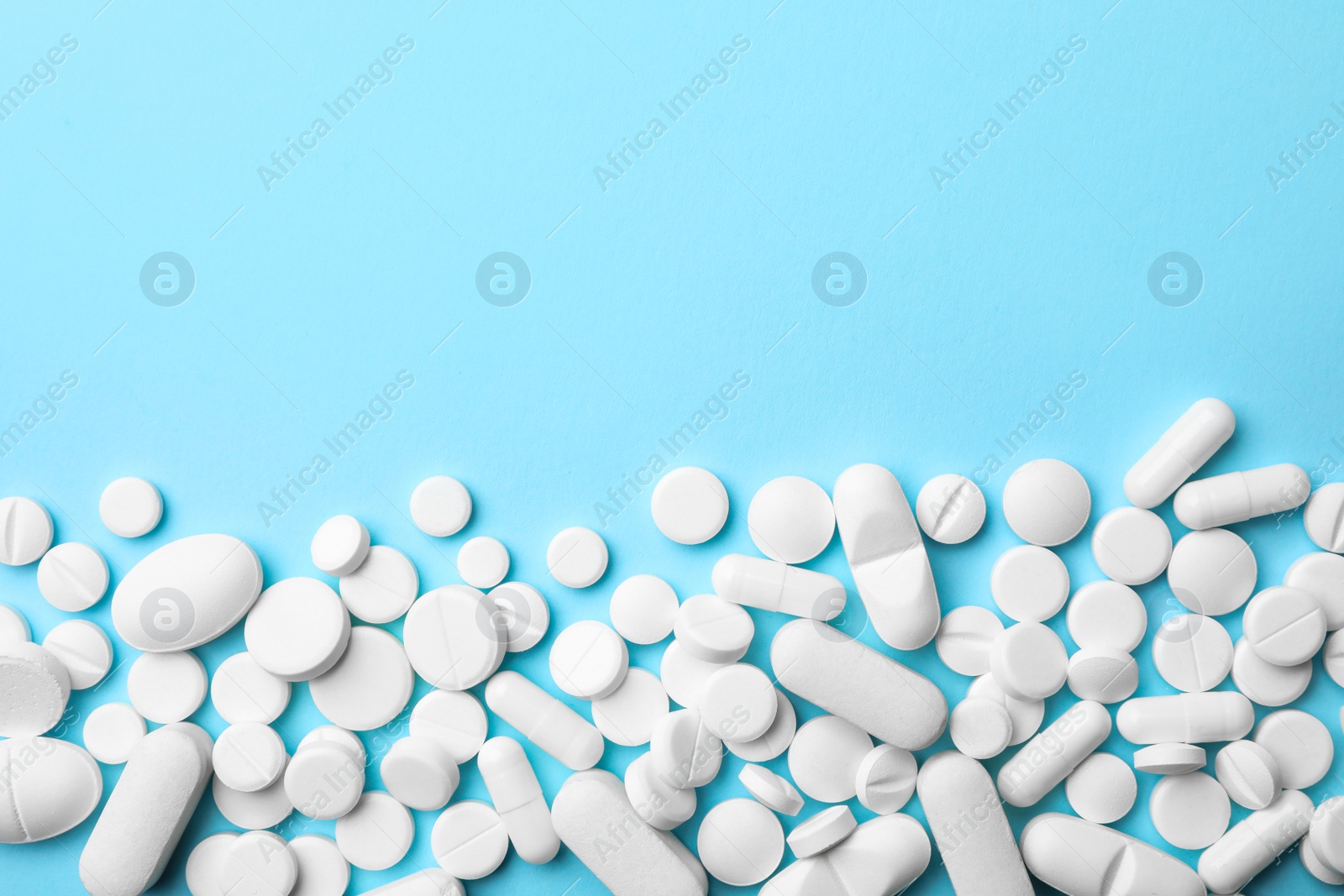 Photo of Different pills on color background, top view. Space for text