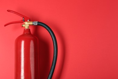 Photo of Fire extinguisher on red background, top view. Space for text