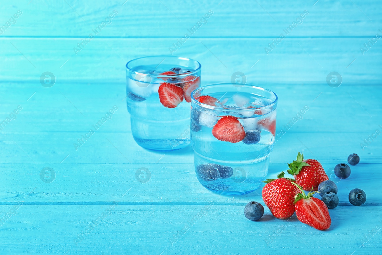 Photo of Natural lemonade with berries in glasses on wooden table