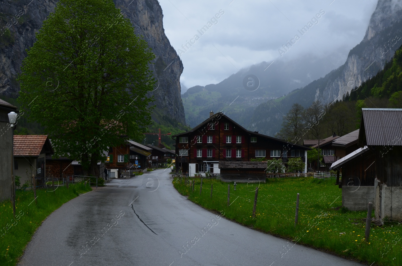 Photo of View of empty asphalt road and buildings in mountains