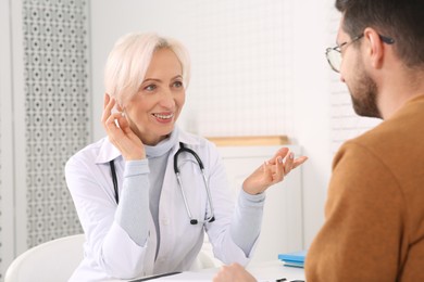Professional female doctor consulting patient in clinic