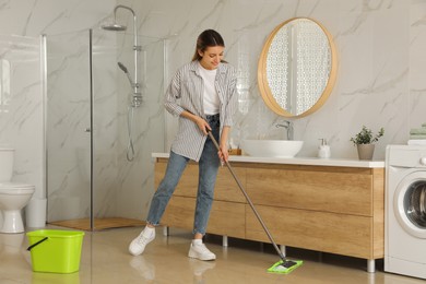 Photo of Woman cleaning floor with mop at home