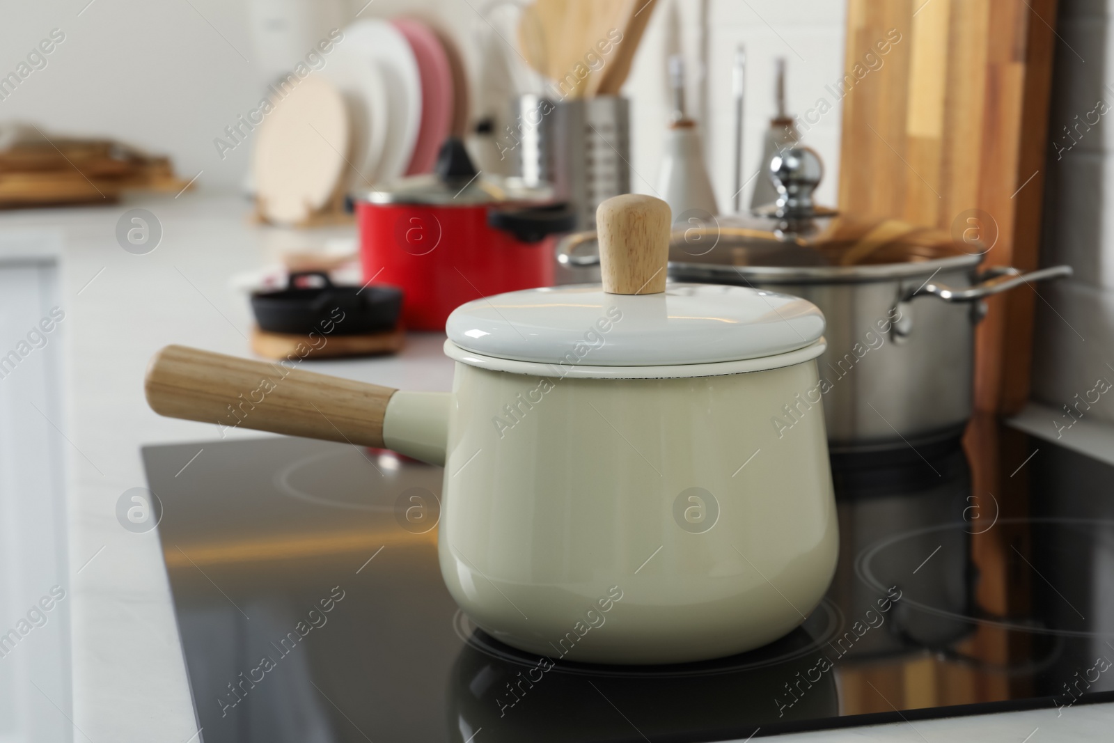 Photo of Saucepan on electric stove in kitchen. Cooking utensil