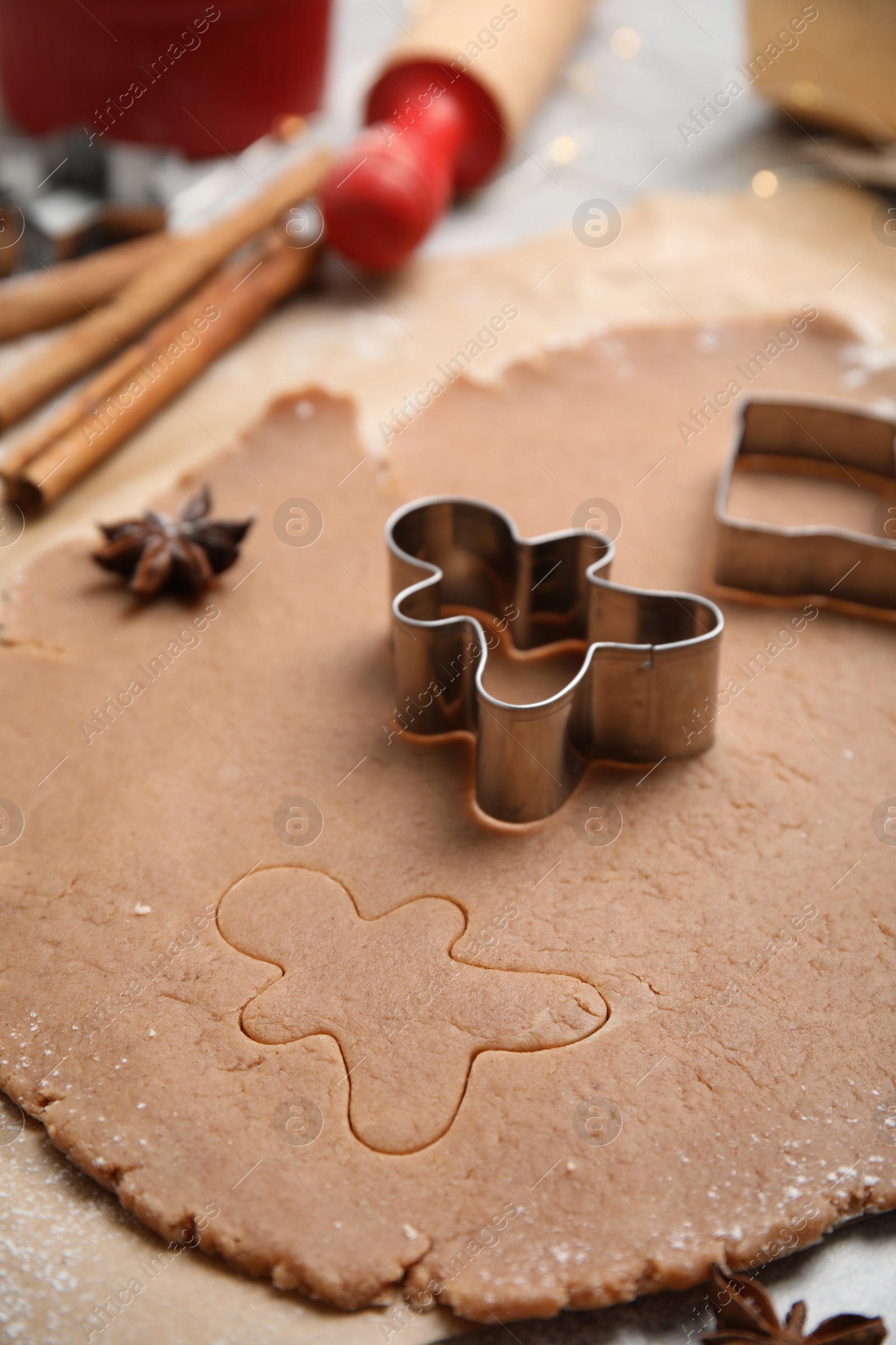Photo of Making Christmas cookies. Raw dough with man shaped cutter on table, closeup