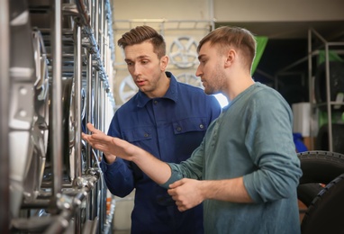 Photo of Service center consultant helping customer to choose alloy wheels in store