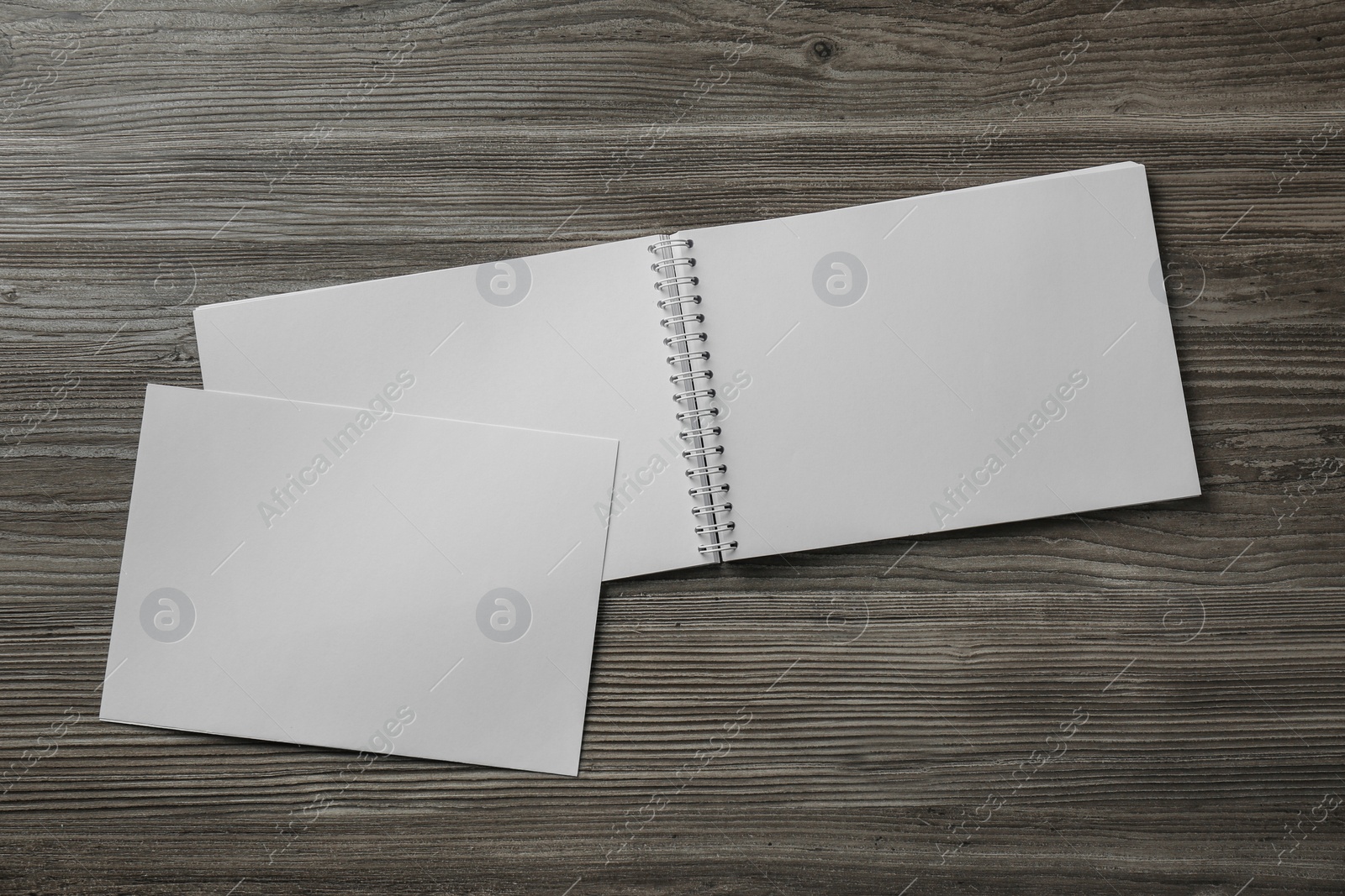 Photo of Sheet of paper and blank brochure on wooden table, flat lay. Mockup for design