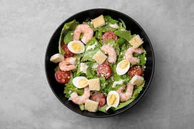 Photo of Delicious Caesar salad with shrimps on grey table, top view