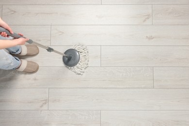 Photo of Woman mopping wooden floor, top view. Space for text