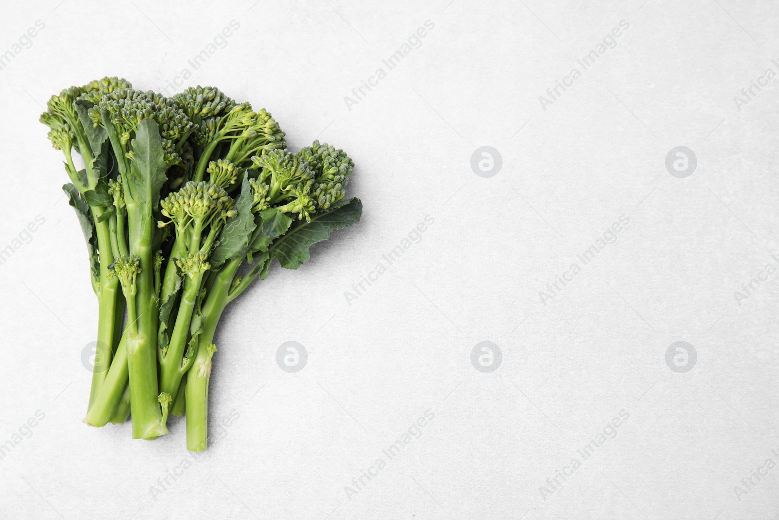 Photo of Fresh raw broccolini on white background, flat lay and space for text. Healthy food