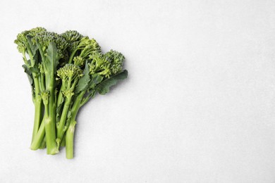 Photo of Fresh raw broccolini on white background, flat lay and space for text. Healthy food