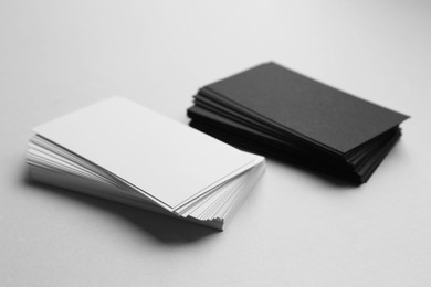 Blank black and white business cards on light background, closeup. Mockup for design