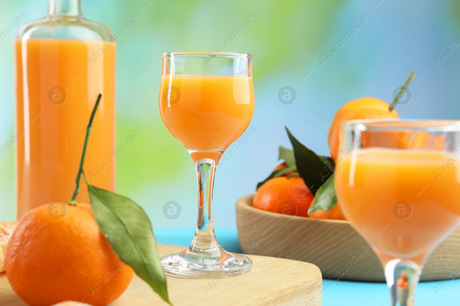 Photo of Delicious tangerine liqueur and fresh fruits on table